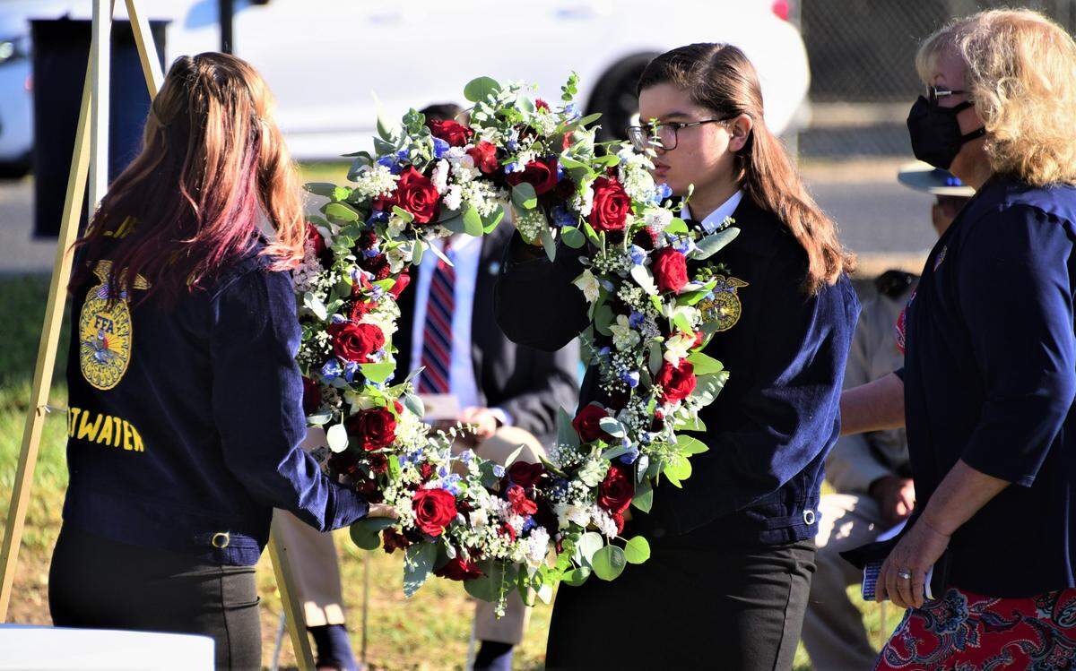 Atwater High Future Farmers of America members Shayleigh Miller (left) and Ella Boyenga and Atwater Rotary President Penny Weaver present a wreath during the City of Atwater’s “Day of Remembrance and Patriot Day” ceremony at the Atwater Community Center on Saturday, Sept. 11, 2021 in Atwater, Calif.