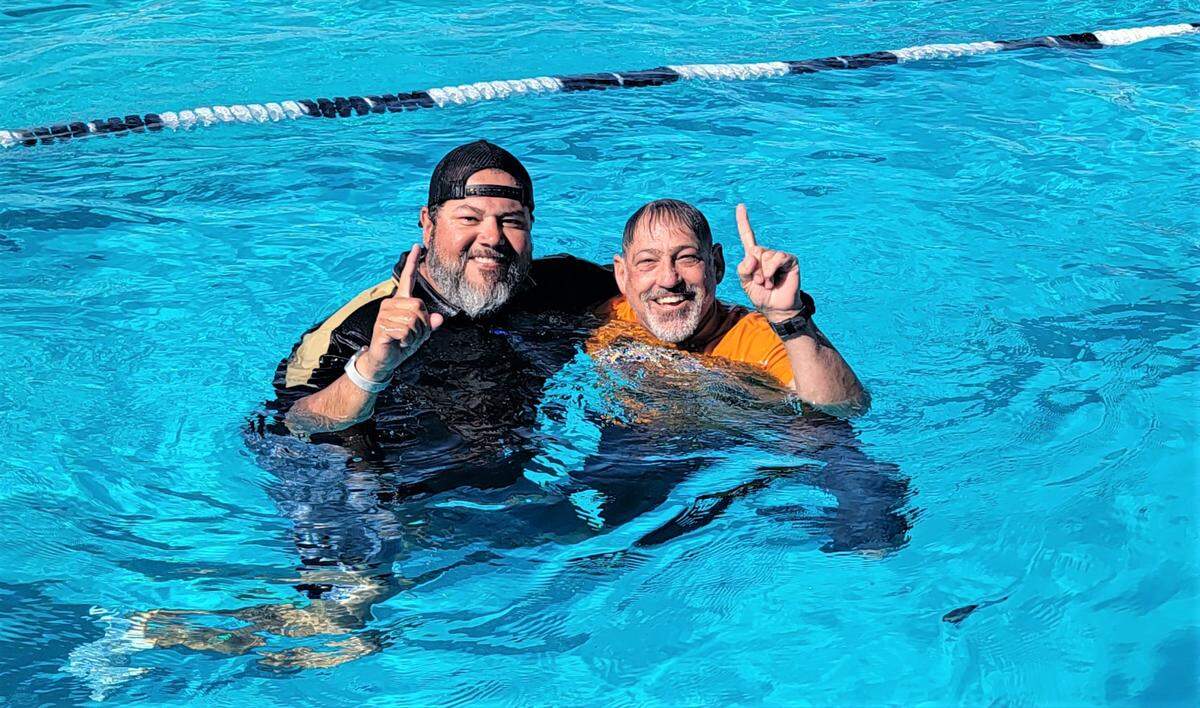 Buhach Colony High School girls swimming coach A.J. Abril (left) and Merced swimming coach Kit Grattan celebrate in the pool after their teams won Central California Conference championships during the league meet on Saturday, April 22, 2022 at Buhach Colony High School.