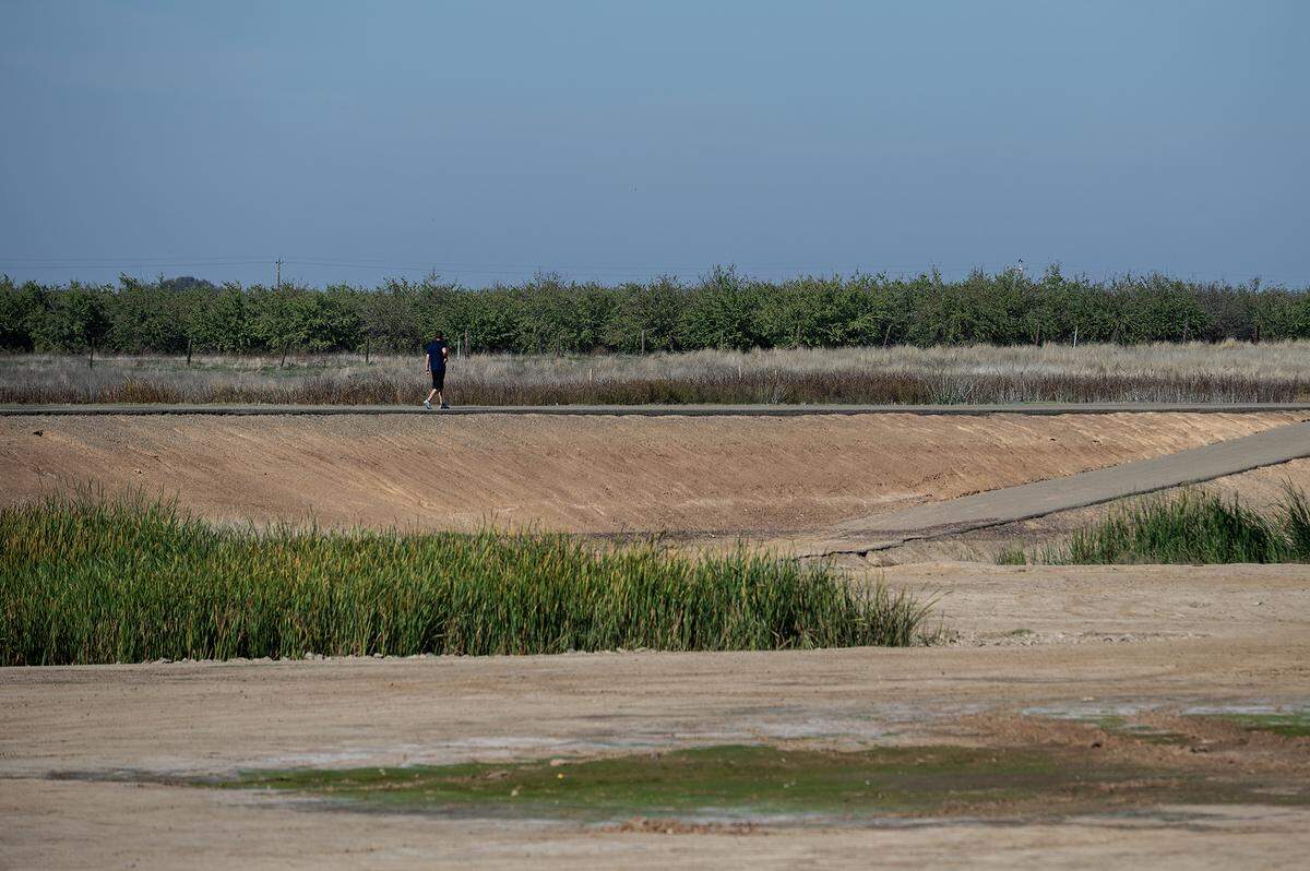 A person walks along a path near the future site of Gen. Vang Pao Park and the Aletha June playground at West Cardella Road and Freemark Avenue in Merced, California, on Thursday, Oct. 30, 2025. 
