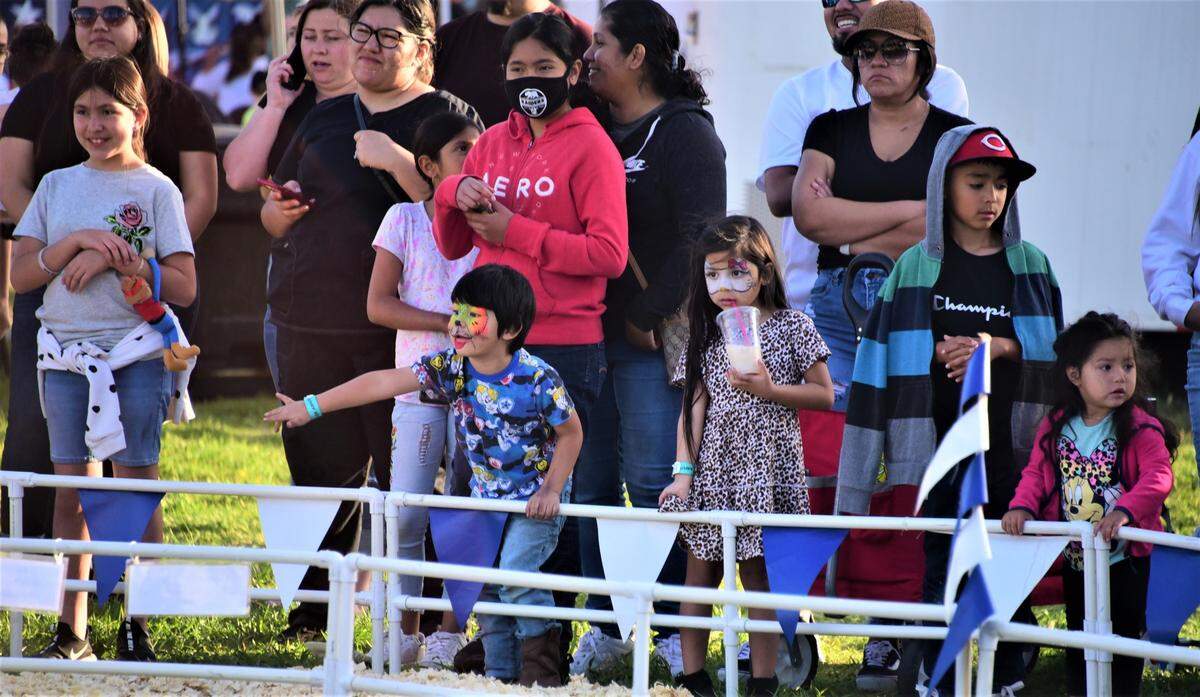 Spectators lined up around the rail to watch the pig races on the opening day of the Merced County Spring Fair in Los Banos on Wednesday, April 27, 2022 in Los Banos, Calif.