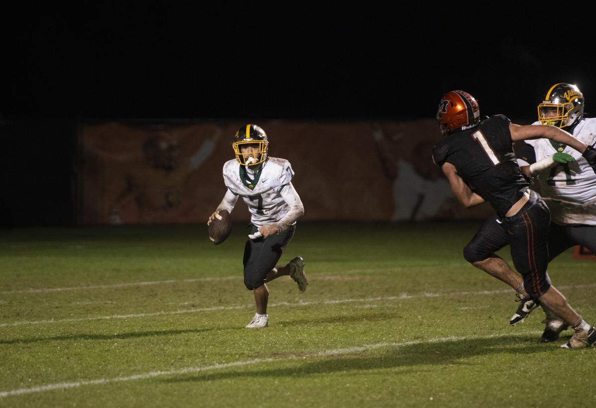 Vanden quarterback Xavier Zambrano scrambles to his right while pressured by Merced’s Hayden Czirban during a Division III playoff game Friday, Nov. 14, 2025, in Merced. Zambrano later threw the go-ahead touchdown in the 26-25 win.