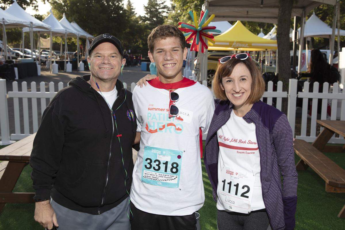 Lucca Lorenzi, center, poses for a photo at the Summer Scamper event with his father Joe and mother Suzie. The Lorenzi family helped raise over $5,000 for the Lucile Packard Foundation for Children's Health.