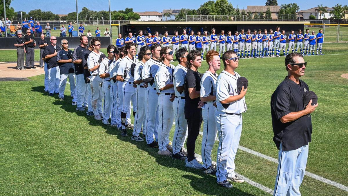 Buhach Colony, in foreground, and De Campo players and coaches face the flag for the National Anthem before their playoff game at Buhach Colony in Atwater on Friday, May 20, 2022.