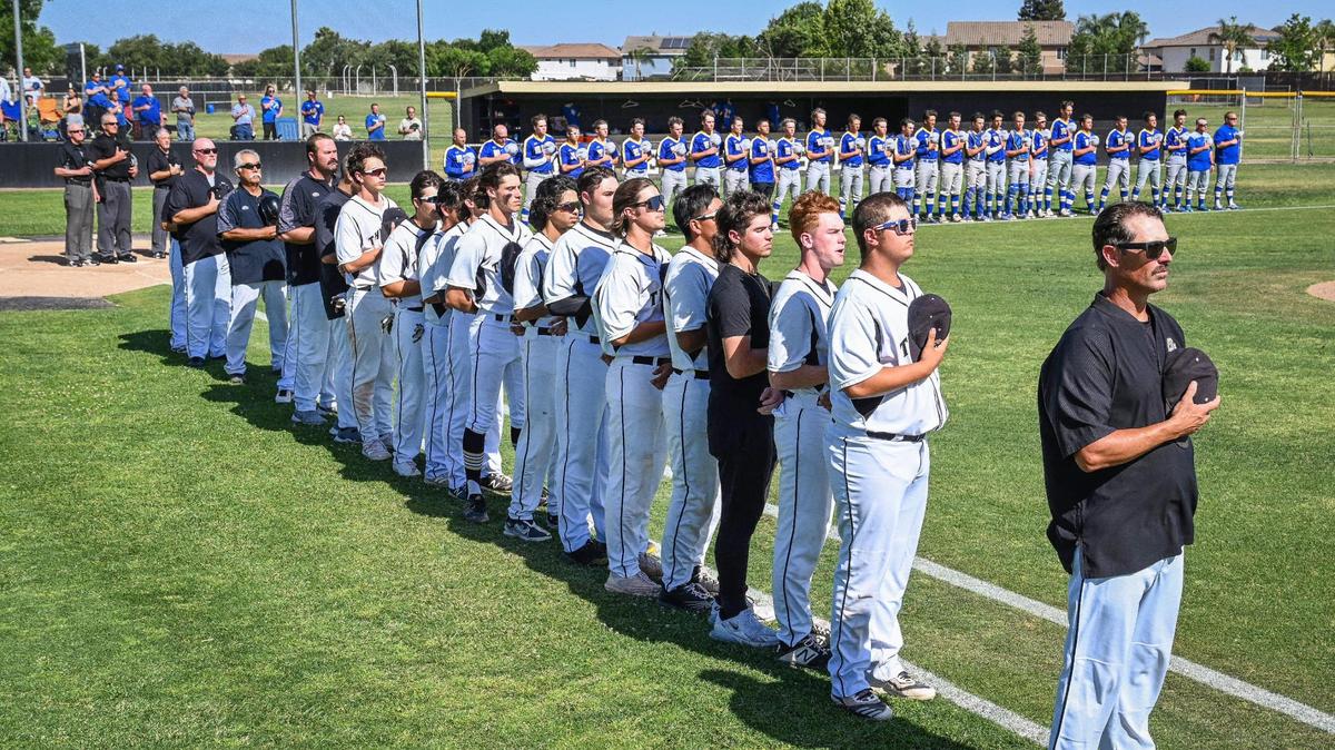 Buhach Colony, in foreground, and De Campo players and coaches face the flag for the National Anthem before their playoff game at Buhach Colony in Atwater on Friday, May 20, 2022.