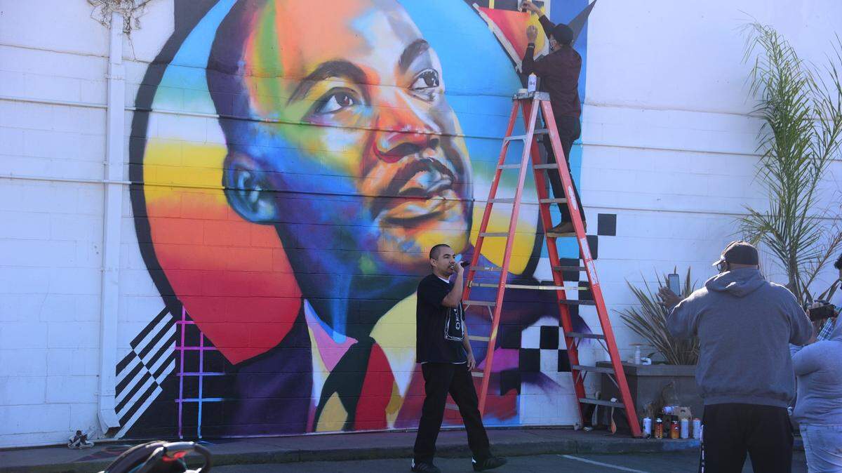 Christian rapper Willie Felix of Merced performs as artist Joel Aguilar of Livingston paints a mural honoring Martin Luther King Jr. on Sunday, Feb. 21, 2021.