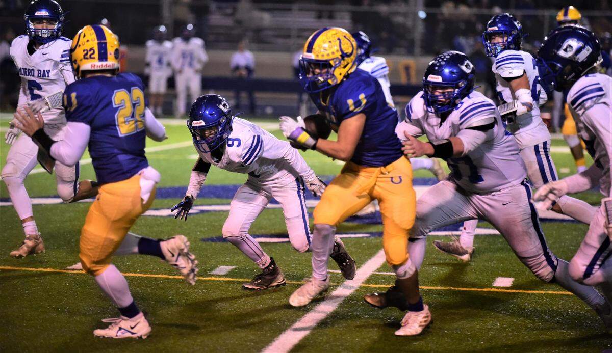 Dos Palos receiver Elias Malfabon hauls in a catch and runs for a big first down in the second half during a 28-27 win over Morro Bay on Thursday, Nov. 10, 2022.