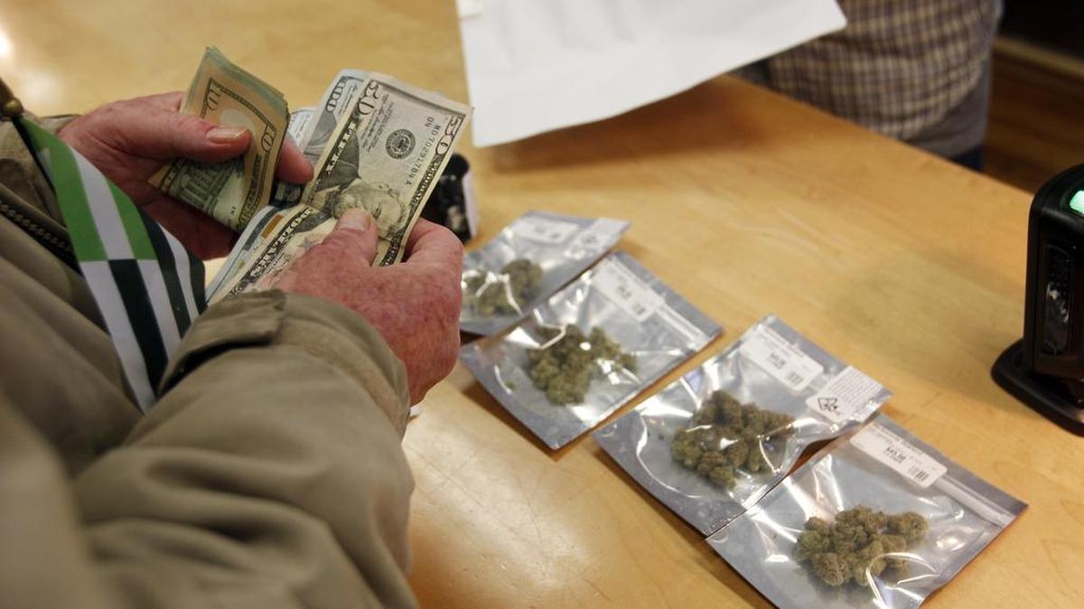 A customer purchases marijuana at Harborside marijuana dispensary, Monday, Jan. 1, 2018, in Oakland, Calif. Starting New Year's Day, recreational marijuana can be sold legally in California.