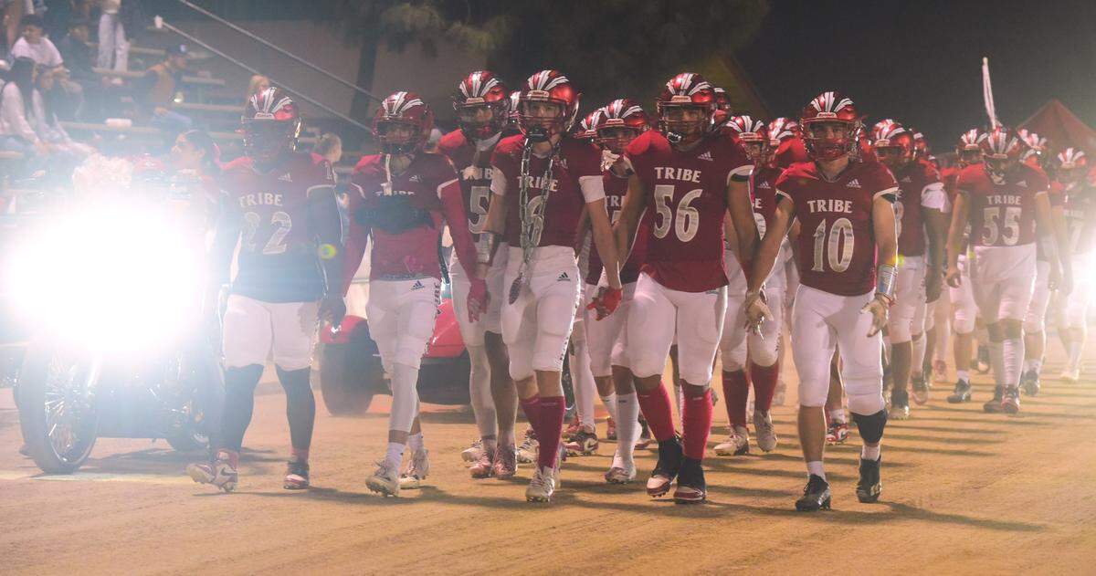 The Chowchilla High football team follows their motorcycle escort into Henry Massaro Stadium on Friday night prior to a game against Minarets in Chowchilla, Calif.