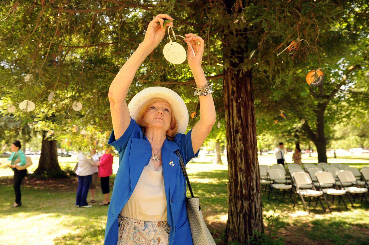 BEA AHBECK CASSON/bahbeck@mercedsunstar.com Jacque MacDonald, founder of Victims’ Voice, hangs a remembrance card for her daughter Debi Anne Whitlock, who was 32 when she was murdered on March 25, 1988, during the Victims’ Rights Ceremony at the Courthouse Park in Merced Thursday. (4-25-13) The event was held by the Merced County District Attorney Victim Witness Assistance Program.
