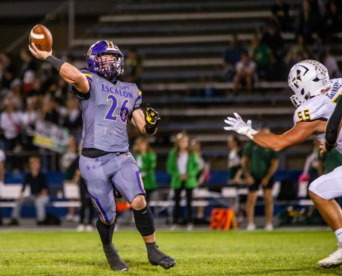 Jamin Miller, 26, of Escalon High throws a pass upfield over Dakota Maynard, 55, and his defensive line Friday Oct. 13, 2023.