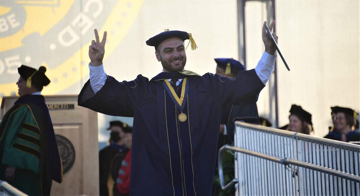 UC Merced graduate student Karen Mohammadtabar raises his arms in the air after receiving his Ph. D in Philosophy Mechanical Engineering during UC Merced’s spring commencement ceremony on Friday, May 12, 2023.