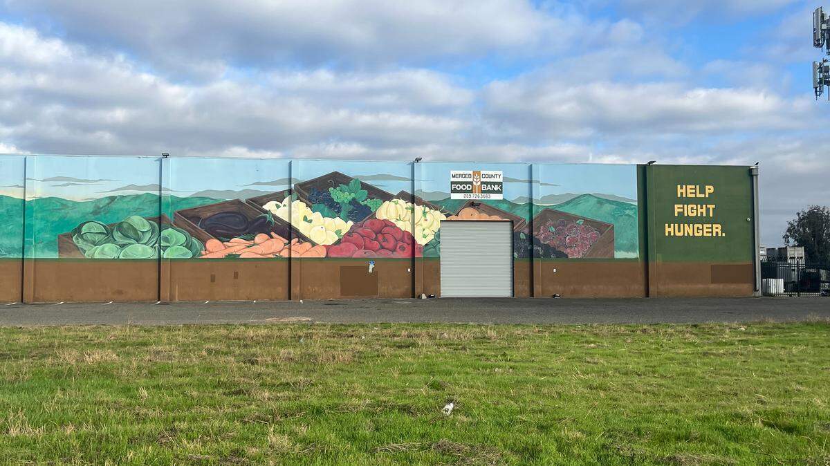 Photo of the outside of the food bank featuring a mural with fresh produce in baskets.