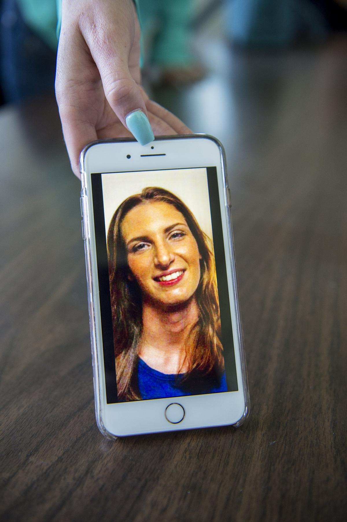 Emma Cunningham shows a photo of her sister, 26-year-old Katherine Cunningham, as family members speak about her in Merced, Calif., on Wednesday, April 25, 2018. Katherine Cunningham was found dead on March 3, 2018, on Camano Island in northwest Washington. Authorities are searching for a man named Jacob Gonzales, 34, who authorities say is a person of interest in Cunningham's death.