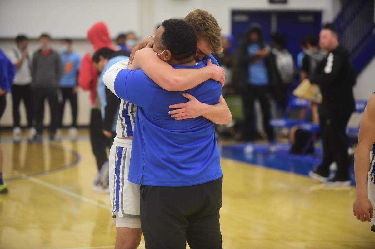Atwater High junior Tyler Parr hugs Falcons assistant coach Seneca Ybarra after an emotional 58-53 win over El Capitan on Friday, Feb. 4, 2022. Parr has been playing with a heavy heart after his father Steven Parr recently died.