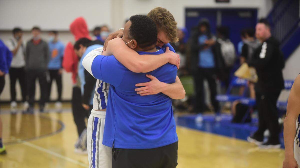 Atwater High junior Tyler Parr hugs Falcons assistant Seneca Ybarra after an emotional 58-53 win over El Capitan on Friday, Feb. 4, 2022. Parr has been playing with a heavy heart after his father, Steven Parr, recently died.