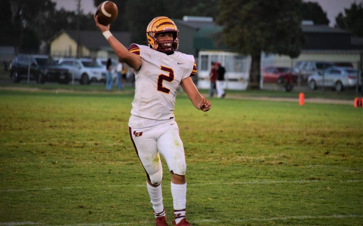 Los Banos High School junior quarterback David Herrera scrambles to throw the ball during a 21-7 loss to Hilmar on Friday, Aug. 26, 2022.