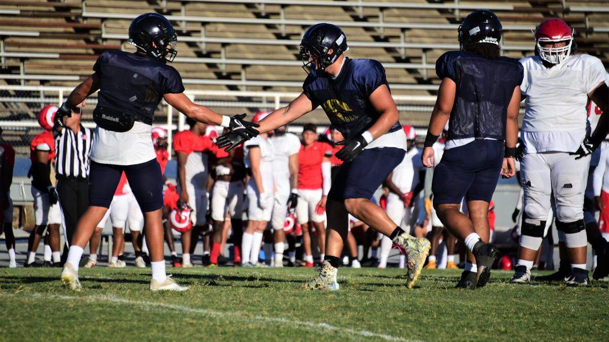 Merced College defensive lineman Samari Russo (right) celebrates with teammate Nate Ruiz (left) after making a play during a scrimmage against Fresno City at Stadium ’76 on Thursday, Aug. 25, 2022.