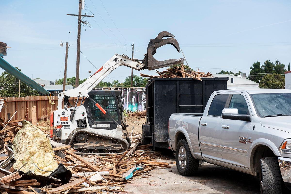 Debris is loaded into a dumpster as the Siesta Motel is demolished at 1347 W. 16th Street in Merced, Calif., on Thursday, Aug. 4, 2022.