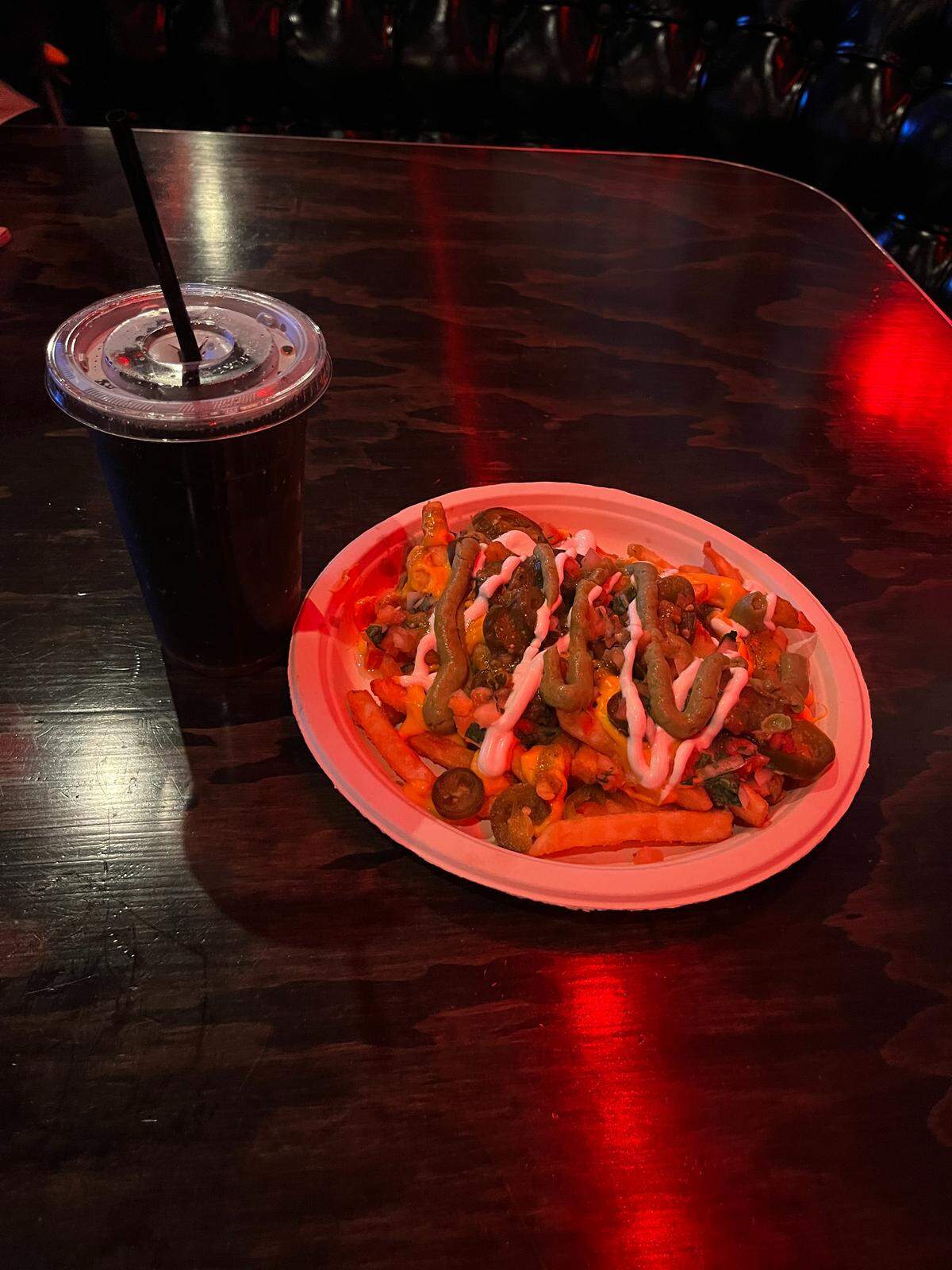 Loaded fries and a diet coke at Joystiq on a dark wood table