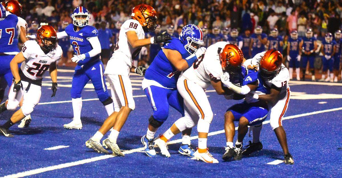 Merced High School senior linebacker Malichi Martin (right) helps tackle an Atwater player during the Santa Fe Bowl on Friday, Sept. 22, 2023.