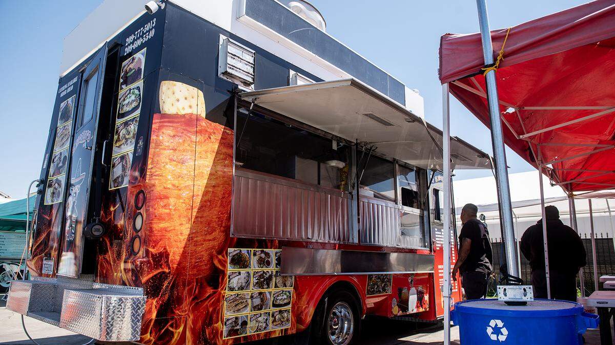 Customers order food from the El Tacoloco Taqueria food truck in a food truck parking area in the lot of Courtesy Rent a Car, 1055 W. 15ht Street in Merced, Calif., on Tuesday, Aug. 12, 2025. The location currently hosts up to nine food trucks offering various cuisine options. 