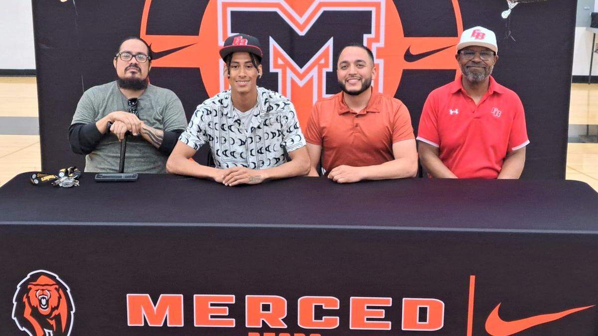 Merced High School senior Cristian Castro signed his national letter of intent to accept a track scholarship with Cal State East Bay on Wednesday, May 17, 2023 at Merced High School. Castro is joined by his father Armando Castro (left) and Merced High spring coach Joe Valenzuela (right) and Cal State East Bay coach Norm Alston (far right).