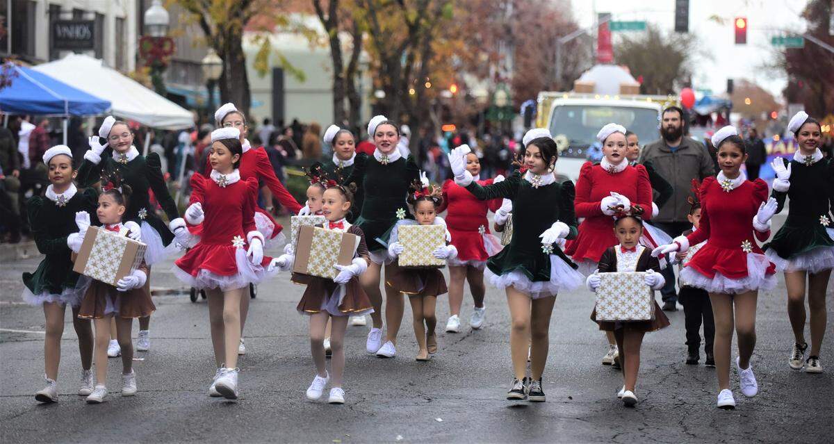 Members of the Revelution Dance Company make their way down Main Street during the Merced Christmas Parade on Saturday, Dec. 3, 2022.