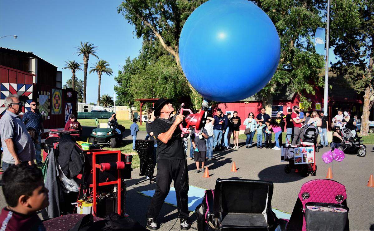 Performer Skip Banks inflates a giant balloon during his comedy show on the opening day of the Merced County Spring Fair in Los Banos on Wednesday, April 27, 2022 in Los Banos, Calif.