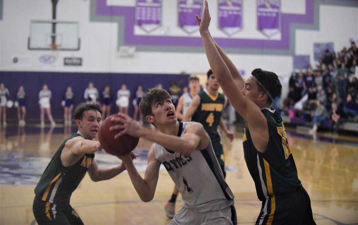 Denair High senior Connor Leonard looks for a shot as he is guarded by Mariposa’s Fernando Garcia (right) and Brayden Fountain (left) during a playoff game on Wednesday, Feb. 23, 2022 at Denair High School.