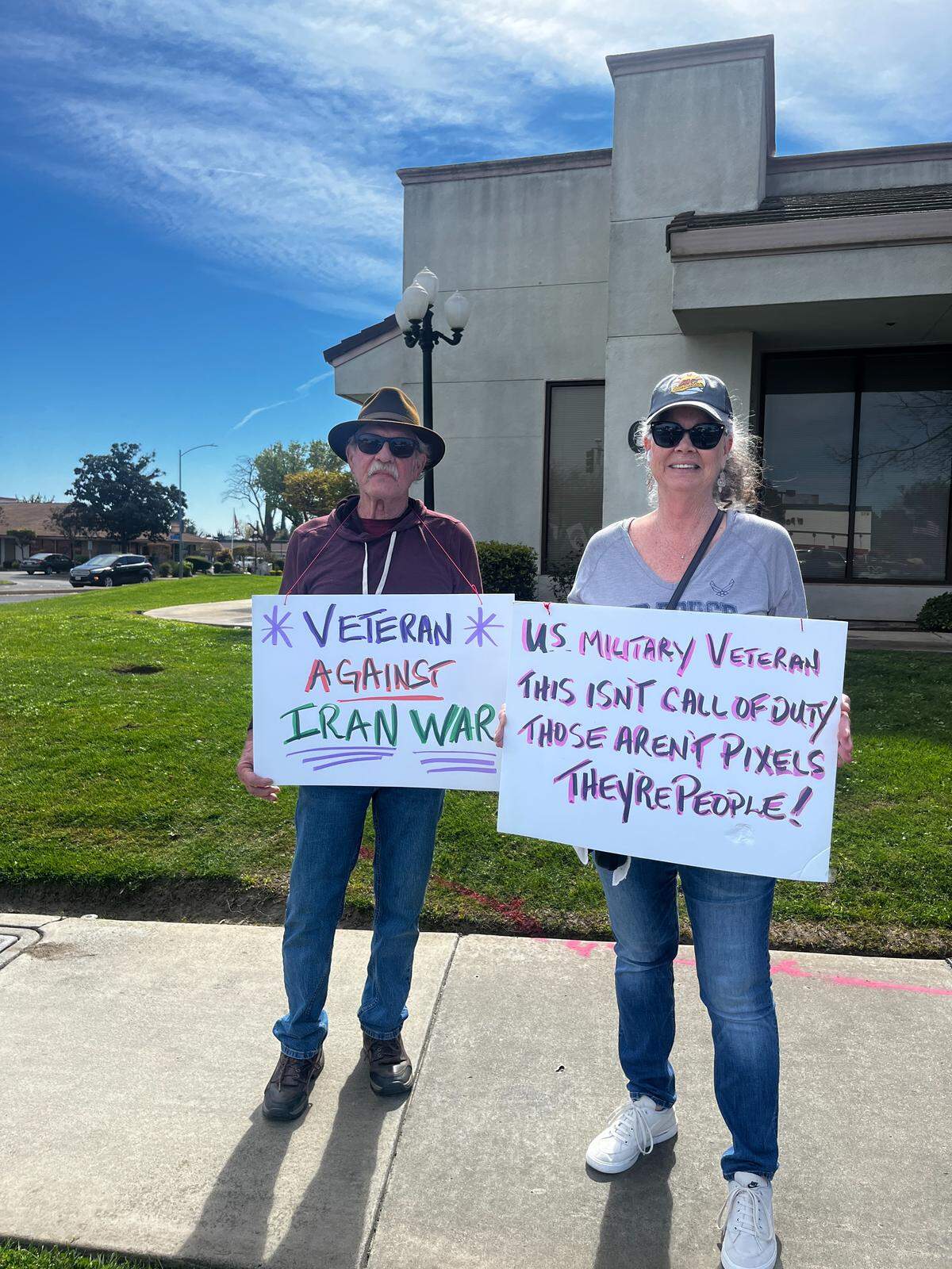 Veterans holding signs protesting the war with Iran.