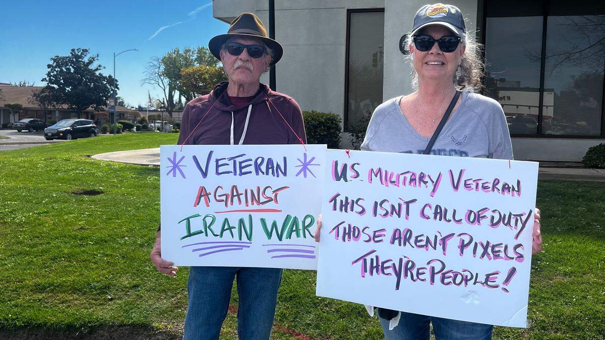 Veterans holding signs protesting the war with Iran.
