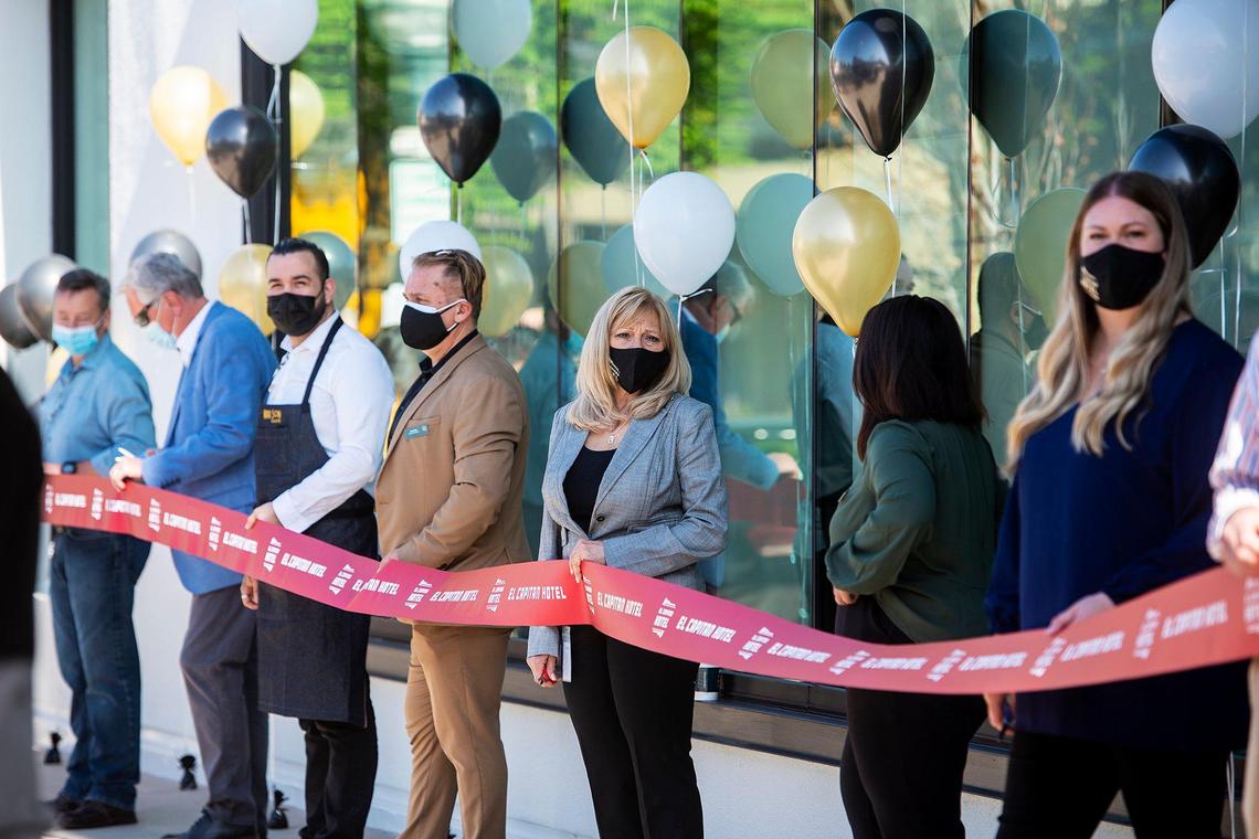 El Capitan Hotel employee hold a ribbon prior to a ribbon cutting ceremony to celebrate the grand opening of the historic El Capitan Hotel, located at 609 W. Main Street in Merced, Calif., on Wednesday, March 31, 2021.