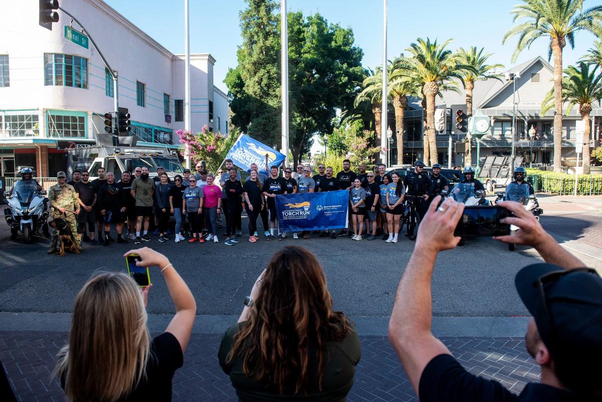 Participants gather for photos after participating in the annual Law Enforcement Torch Run for Special Olympics Northern California in Merced, Calif., on Wednesday, June 26, 2024.