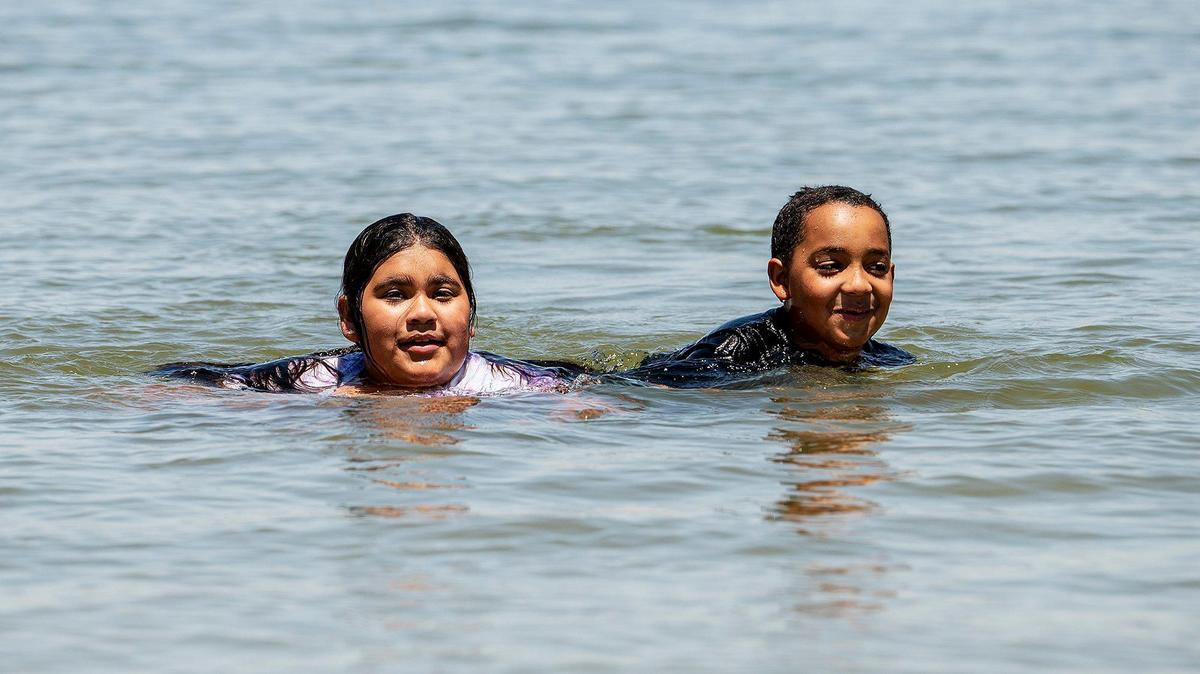 Kaylee Hernandez, 12, left, and Adrian Pittman, 8, both of Bakersfield, cool off in Lake Yosemite while in town visiting family with their grandmother, in Merced, Calif., on Thursday, July 8, 2021.