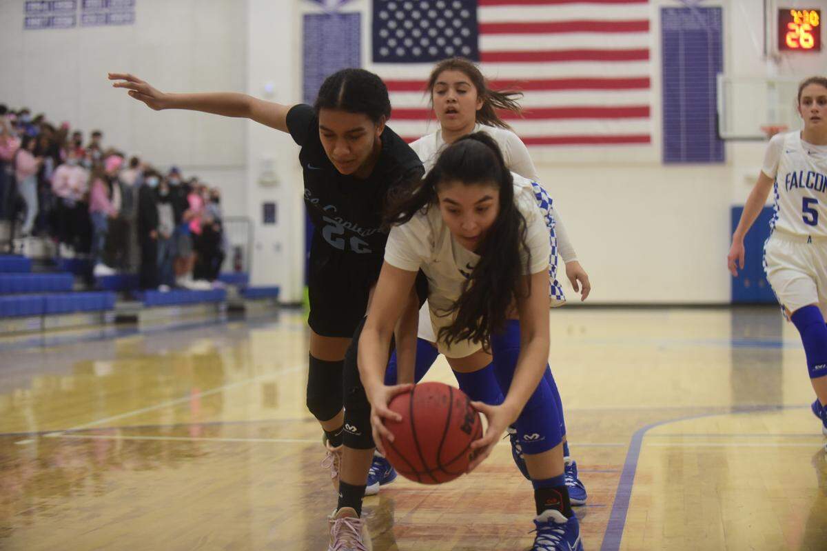 Atwater High senior May Manzanares (right) battles for a loose ball with El Capitan’s Chanel Polk during a game on Thursday, Feb. 3, 2022 at Atwater High School in Atwater, Calif.