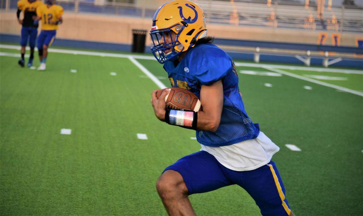 Dos Palos High School running back Mike Cantu runs the ball during practice on Tuesday, Aug. 16, 2022.