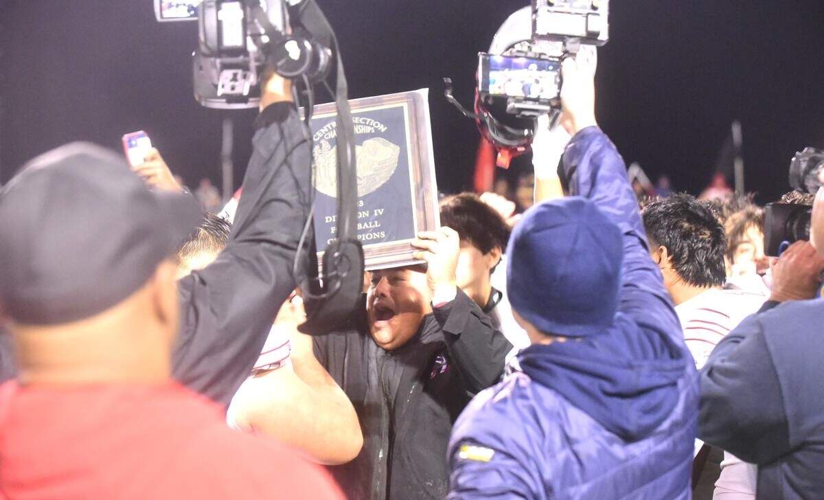 Torres High School football coach Joe Marquez holds up the Central Section championship plaque after the Toros defeated Dos Palos 69-14 in the Division IV championship game on Friday, Nov. 24, 2023 at Bill Hume Stadium in Dos Palos, Calif.