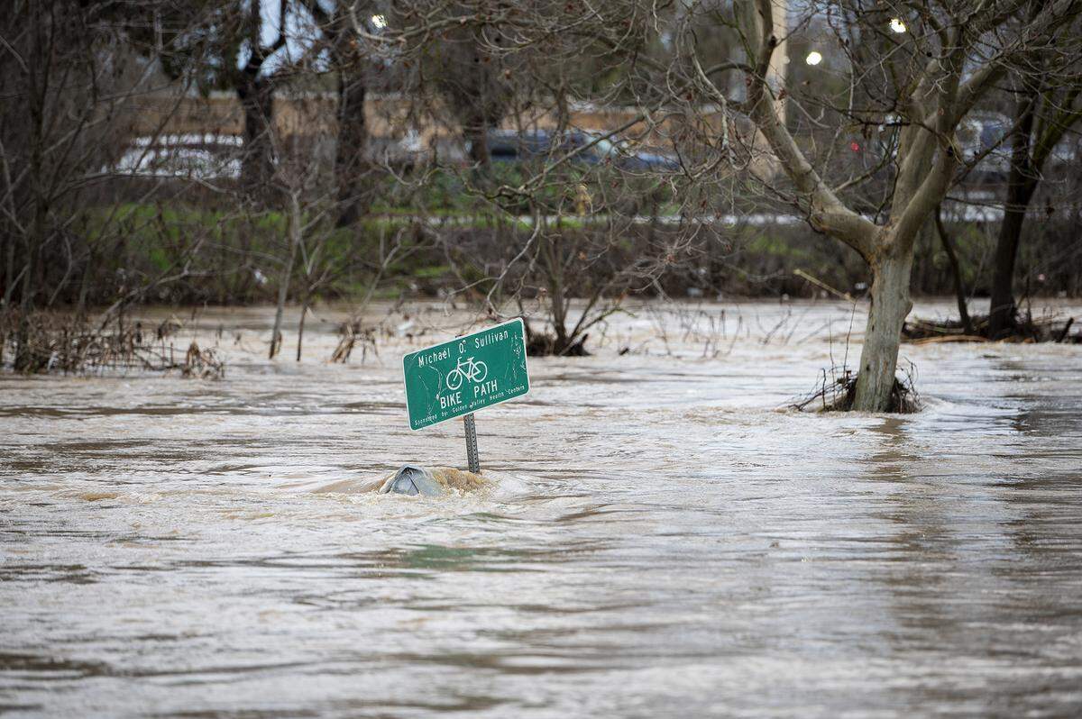 Bear Creek flows past G Street flooding the Michael O. Sullivan bike path and the surrounding area in Merced, Calif, on Tuesday, Jan. 10, 2023.