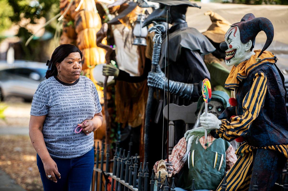 Taryn Powell, 68, of Merced, stops to look at the elaborate display of Halloween decorations in the yard of 28-year-old Merced resident Miguel Avila, at his home on West 9th Street in Merced, Calif., on Thursday, Oct. 17, 2024. “It’s out of sight,” said Powell of the yard filled with decorations and animatronics. “I wish I could do something like this.”