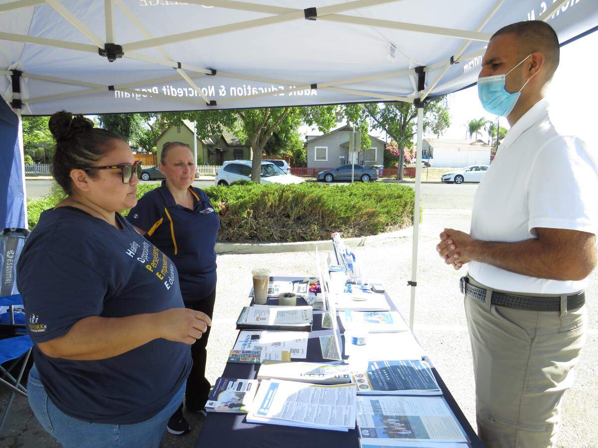 Jennifer Velasquez, left, and Elizabeth Casillas from Merced College explain to Jason Samran, an open house attendee, the educational opportunities Merced College provides to probation clients.