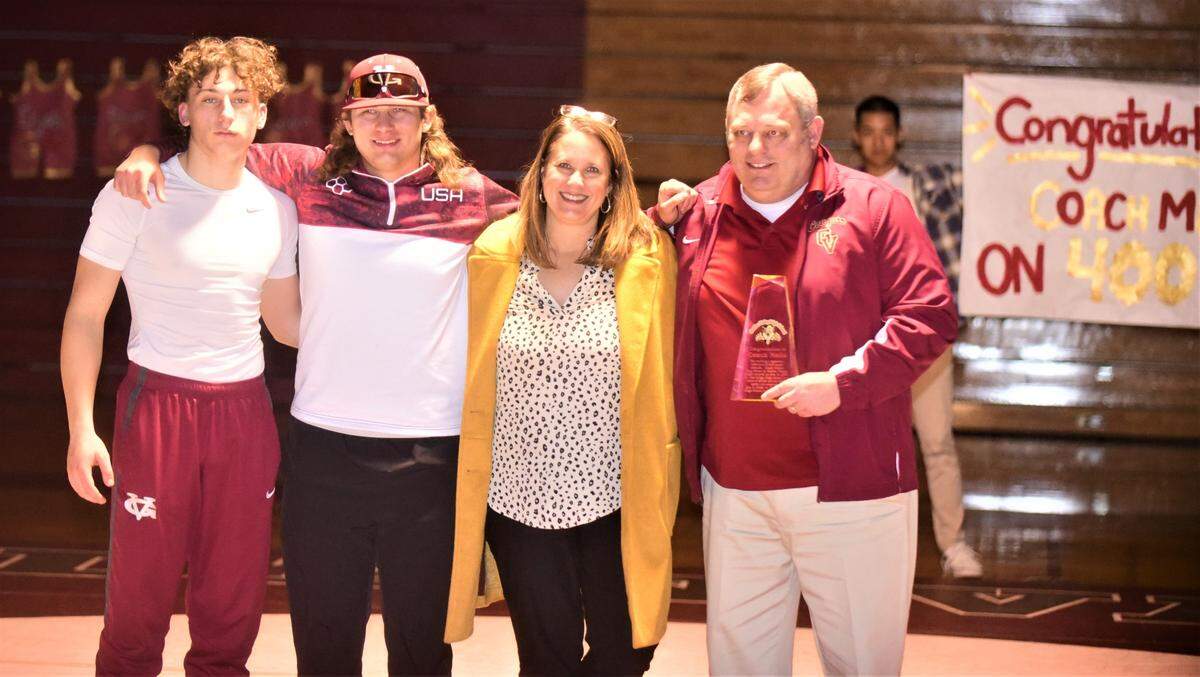 Golden Valley High School wrestling coach Chopper Mello (right) is joined by his wife Amy and two of his sons Austin (left) and Jaret (center) during a ceremony honoring the Cougars coach for his 400th career win on Tuesday, Jan. 17, 2023.