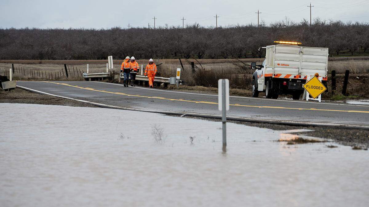 Caltrans crews work to reopen a previously flooded section of Highway 59 between Bellevue Road and Oakdale Road in Merced County, Calif., on Thursday, Jan. 5, 2023.