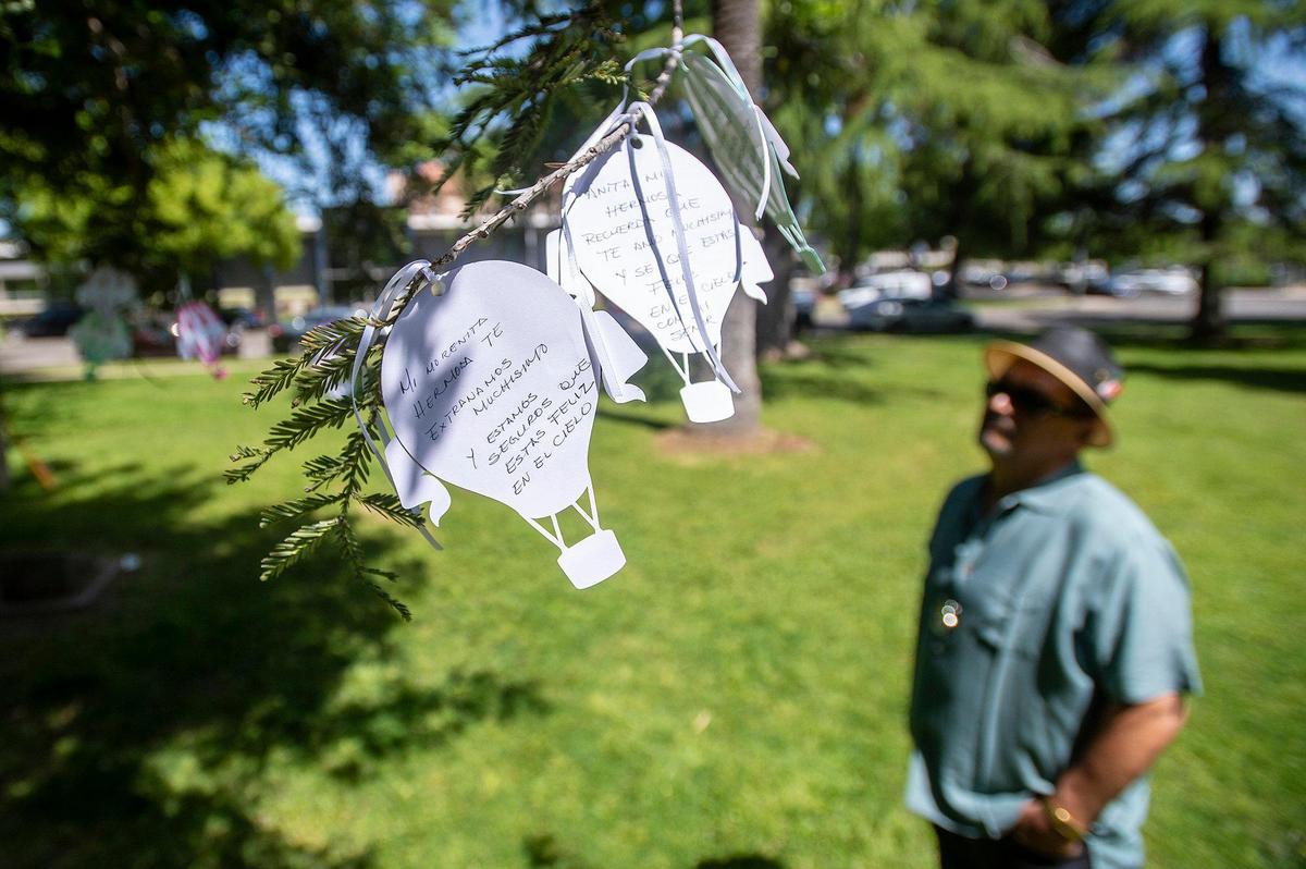 Paper balloons hang from a tree containing messages and names of victims of violence and crime during the Merced County Victims’ Rights Ceremony at Courthouse Park in Merced, Calif., on Tuesday, April 25, 2023. The annual event held to remember victims of violence and crime, is hosted by the Merced County District Attorney’s Office during National Crime Victims’ Rights Week.