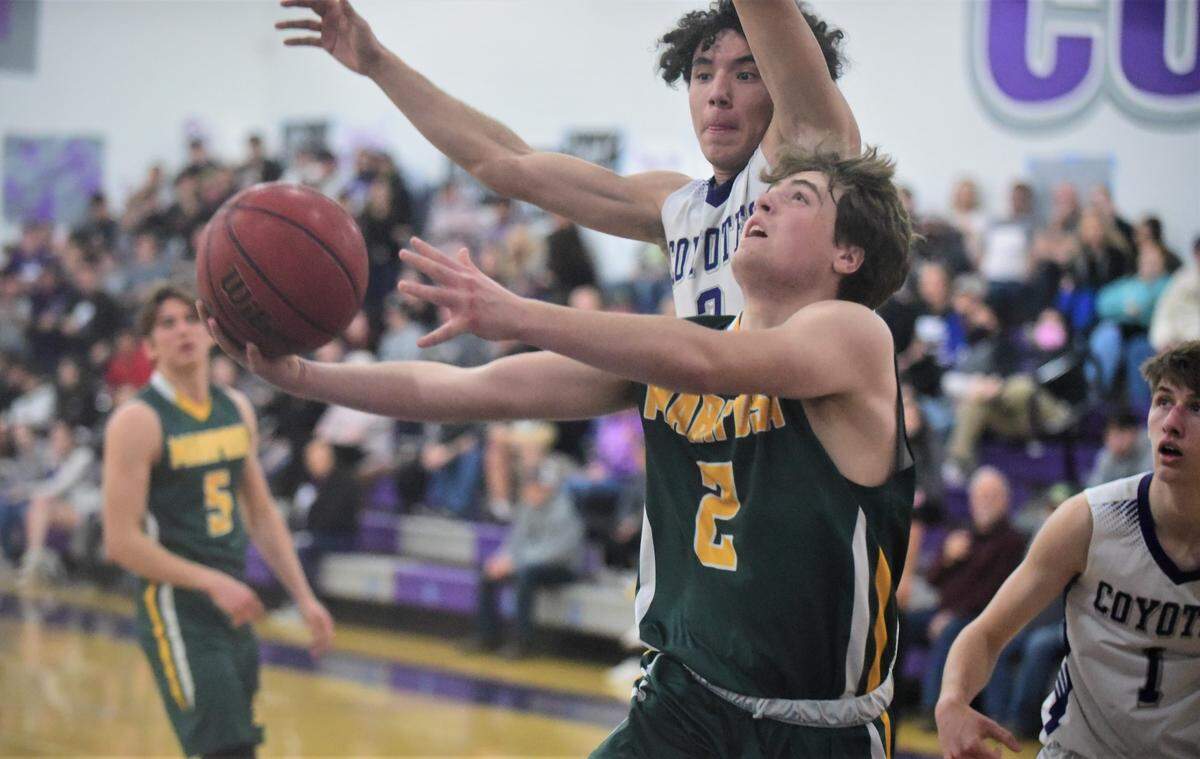 Mariposa High junior Cole Atkins tries to get his shot up against Denair senior Mario Plasencia (3) during a playoff game on Wednesday, Feb. 23, 2022 at Denair High School.
