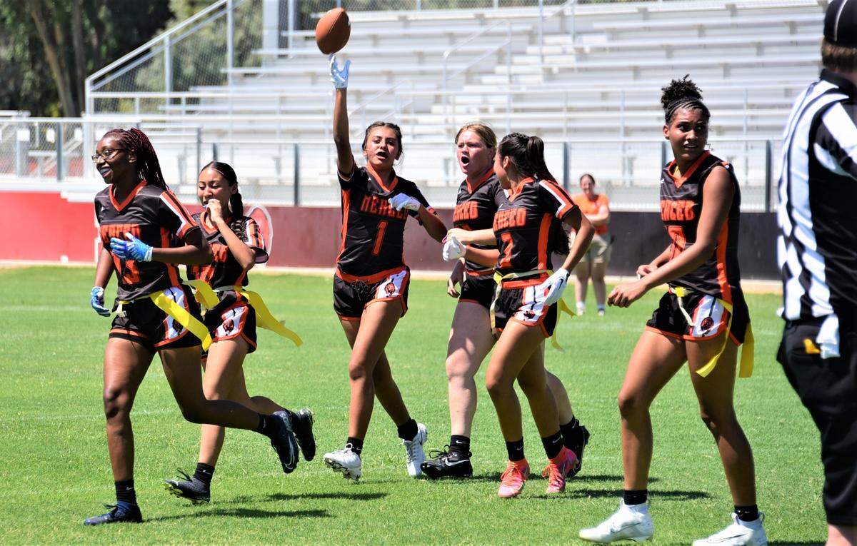 Merced High School senior Emilia Gomez (1) celebrates with her teammates after intercepting a pass late during a flag football game against Atwater on Saturday, Aug. 19, 2023 at Merced High School in Merced, Calif.