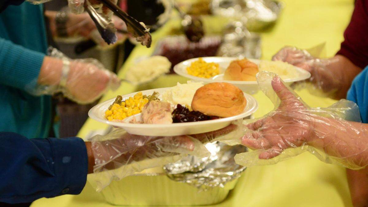 Volunteers are shown dishing out food to more than an estimated 1,000 people at the annual Merced County Rescue Mission Thanksgiving meal.