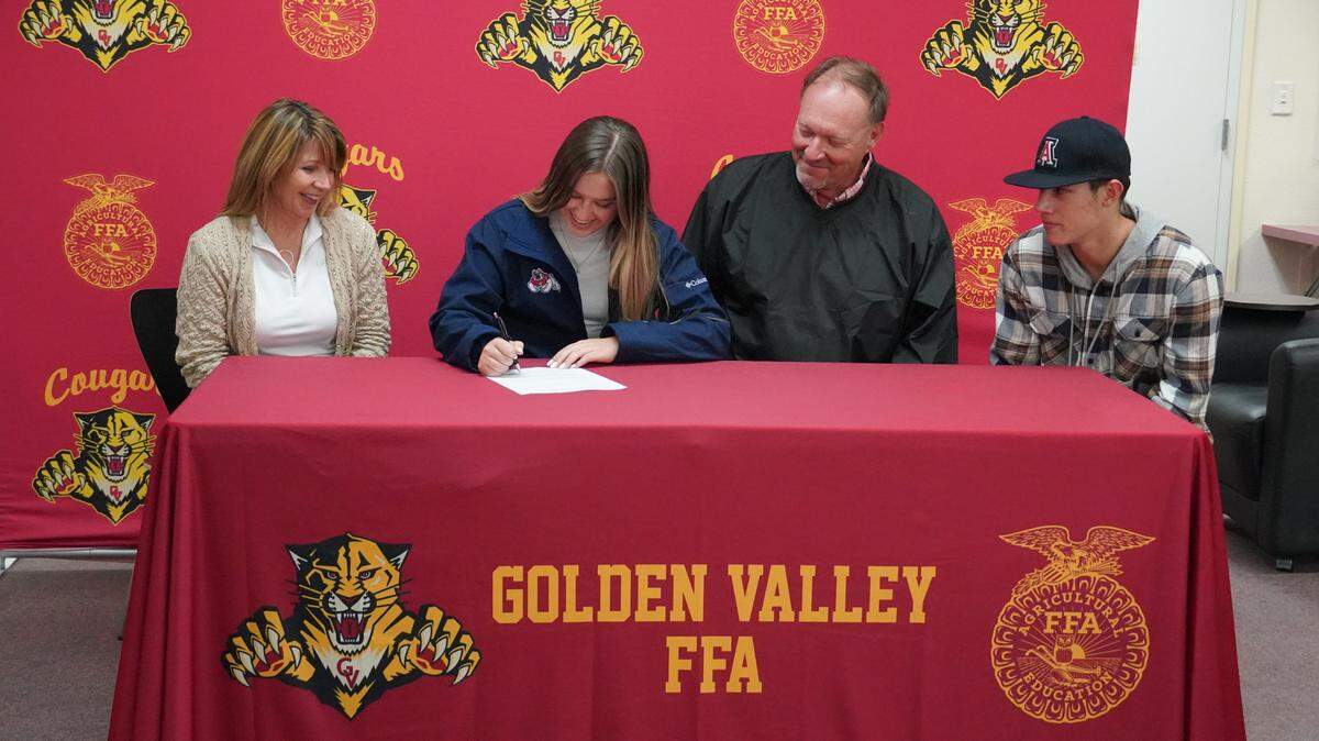 Golden Valley senior Alison Heupel (center) signs her national letter of intent to accept an equestrian scholarship to Fresno State as her mother Paula, father Keith and brother Koen look on during a ceremony at the Golden Valley High School library on Friday, Jan. 21, 2022.