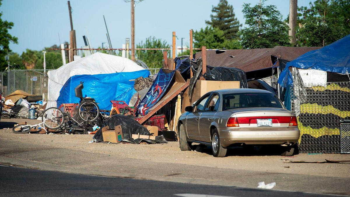 An encampment is seen along the Highway 99 south on-ramp off of G Street in Merced, Calif., on Thursday, May 6, 2021.