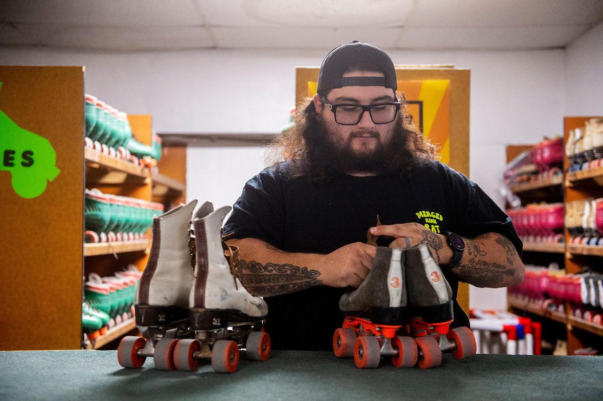 Roll-er Land employee and disc jockey C.J. Gonzalez, 24, of Merced, handles returned roller skates at Roll-er Land in Merced, Calif., on Sunday, Oct. 27, 2024