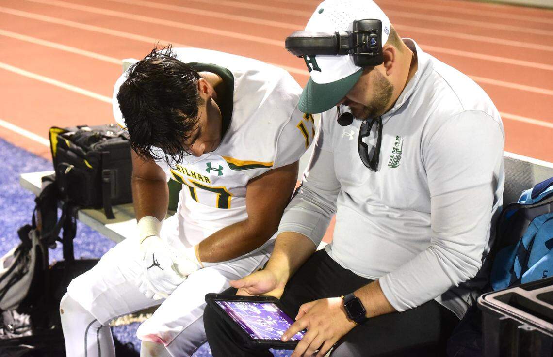 Hilmar High senior Juan Ponce (17) watches video plays with a Yellowjackets assistant coach during a game against Atwater on Sept. 13, 2024.